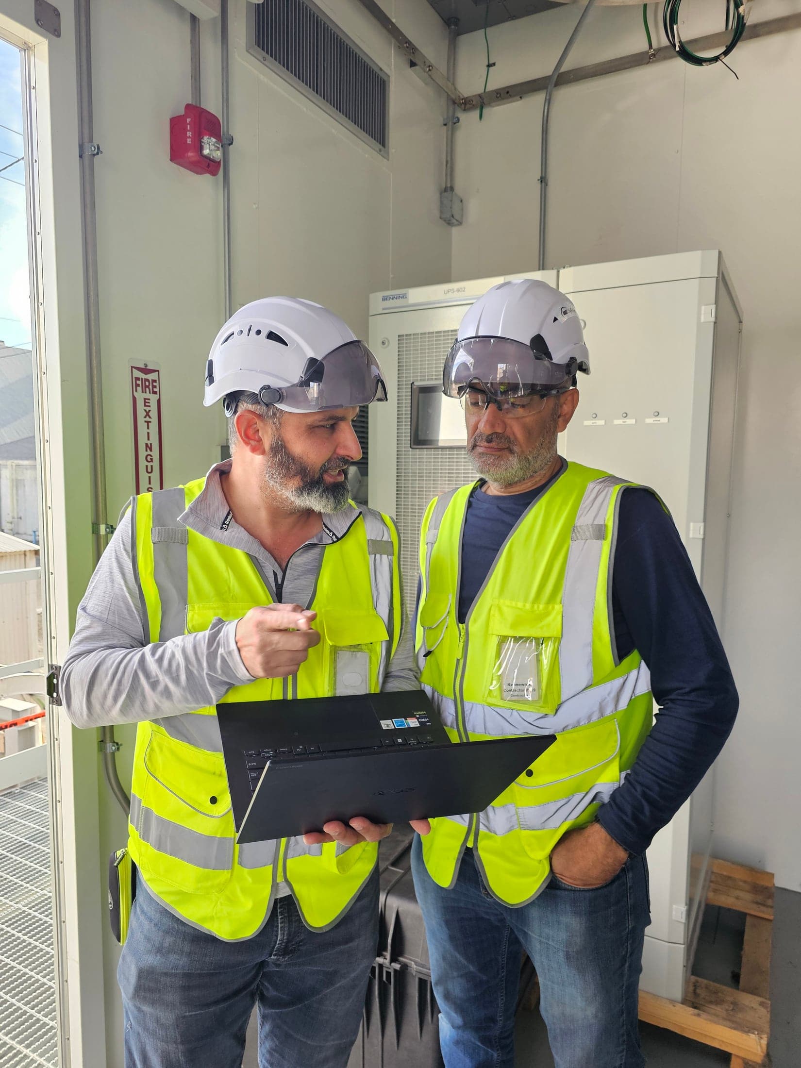 Technicians reviewing test results at a UPS installation
